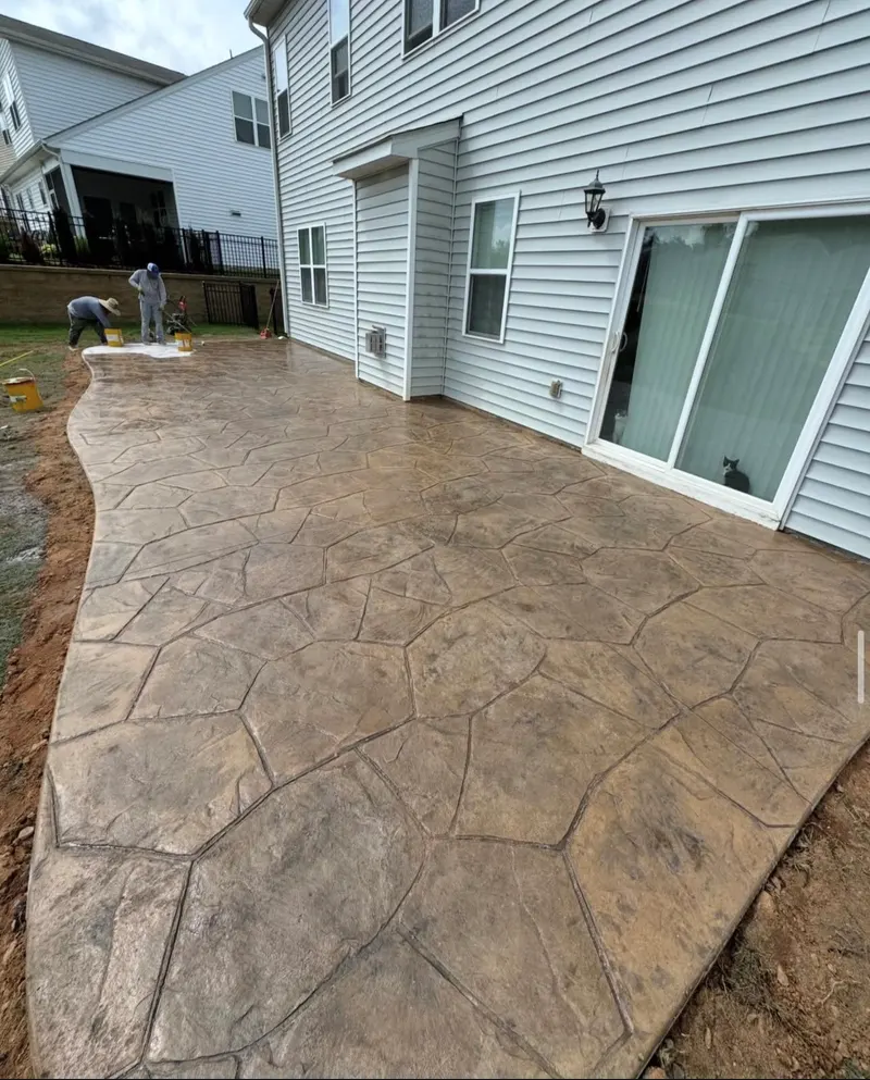 Tan flagstone-pattern stamped patio behind a Charlotte home