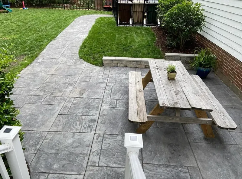 Stamped concrete walkway with seat wall through a Charlotte backyard